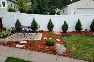 Design ideas for a mid-sized traditional full sun backyard stone landscaping in Minneapolis for summer.