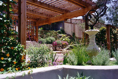 Ejemplo de jardín de secano clásico en patio trasero con exposición total al sol y adoquines de piedra natural