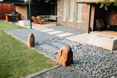 Modelo de jardín minimalista de tamaño medio en patio trasero con exposición total al sol y gravilla