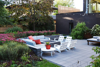 Ejemplo de jardín de secano minimalista pequeño en verano en patio trasero con brasero, exposición total al sol y adoquines de piedra natural