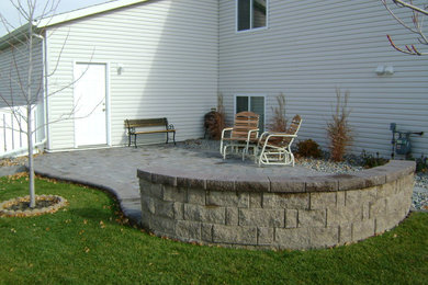 This is an example of a small partial sun backyard concrete paver landscaping in Other.
