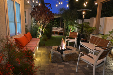 This is an example of a mid-sized rustic drought-tolerant and full sun backyard concrete paver landscaping in Los Angeles with a fire pit for fall.