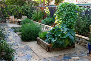 Ejemplo de jardín actual pequeño en patio trasero con brasero, exposición parcial al sol y adoquines de piedra natural