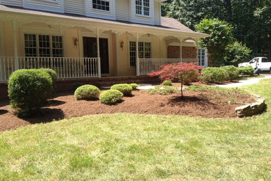 Inspiration for a mid-sized full sun front yard mulch retaining wall landscape in New York.
