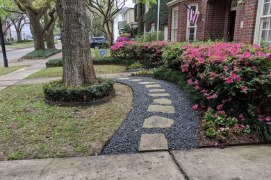 Photo of a mid-sized traditional drought-tolerant front yard gravel landscaping in Houston.
