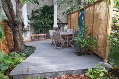 Пример оригинального дизайна: тенистый участок и сад среднего размера на заднем дворе в современном стиле с настилом