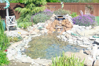 Ejemplo de jardín tradicional grande en patio trasero con fuente, exposición total al sol y adoquines de piedra natural