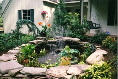 This is an example of a small traditional partial sun backyard stone water fountain landscape in New York.