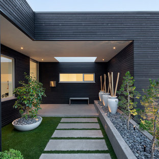 Photo of a modern partial sun front yard concrete paver garden path in Portland.