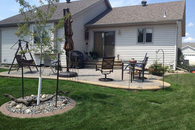 This is an example of a mid-sized traditional full sun backyard concrete paver landscaping in Other.