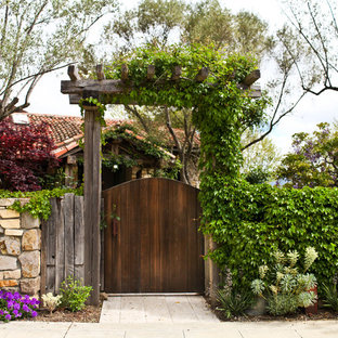 Immagine di un giardino mediterraneo esposto in pieno sole davanti casa e di medie dimensioni in primavera con pavimentazioni in pietra naturale e un ingresso o sentiero