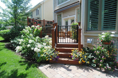 На фото: солнечный участок и сад среднего размера на заднем дворе в классическом стиле с клумбами, хорошей освещенностью и настилом