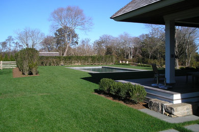 Imagen de jardín tradicional grande en primavera en patio trasero con exposición total al sol y adoquines de piedra natural