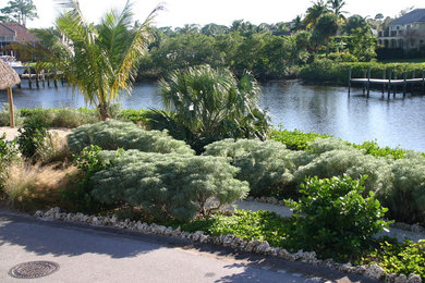 Design ideas for a mid-sized coastal drought-tolerant and full sun hillside gravel garden path in Miami for summer.