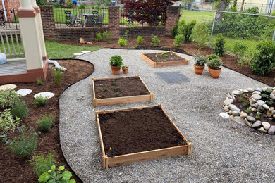 Diseño de jardín de secano actual de tamaño medio en primavera en patio trasero con huerto, exposición total al sol y gravilla