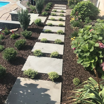 Natural antique bluestone wall with plantings and bluestone steppers