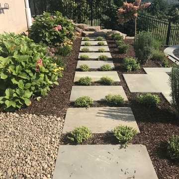 Natural antique bluestone wall with plantings and bluestone steppers