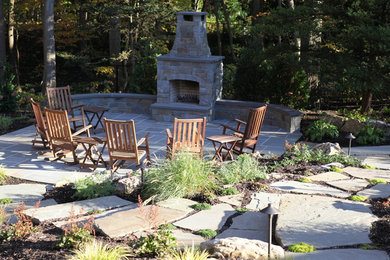 This is an example of a mid-sized rustic partial sun side yard stone landscaping in New York with a fire pit.