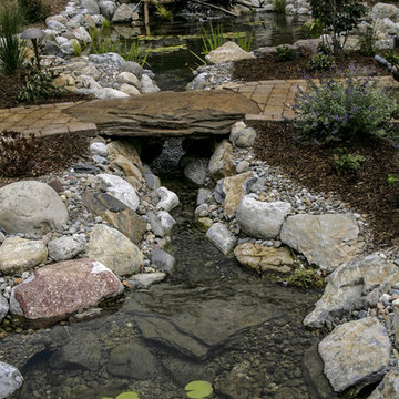 Natural pond with stone edging and natural stone bridge