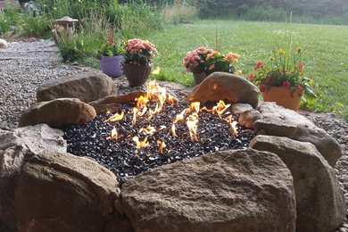 Inspiration for a large traditional full sun backyard gravel landscaping in Detroit with a fire pit.