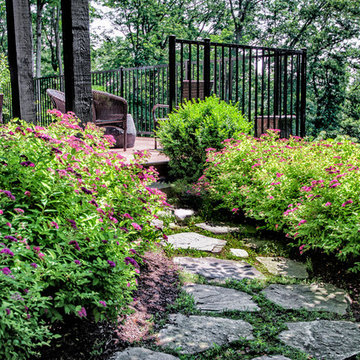 Natural stone path flanked by Spirea and Boxwood