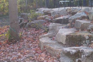 Design ideas for a rustic backyard retaining wall landscape in Indianapolis.