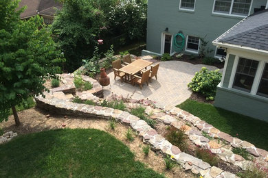Natural stone terraced backyard with paver patio