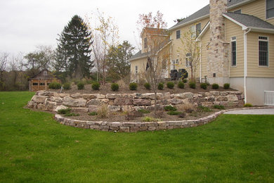 Imagen de jardín rural de tamaño medio en patio trasero con muro de contención, exposición total al sol y adoquines de piedra natural