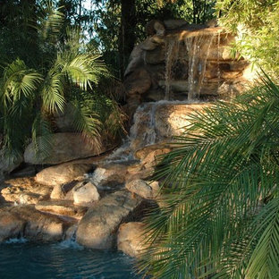 Idee per un grande giardino formale tropicale esposto a mezz'ombra davanti casa con fontane e pavimentazioni in pietra naturale