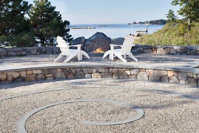 Medium sized classic back xeriscape full sun garden for summer in New York with a fire feature and gravel.