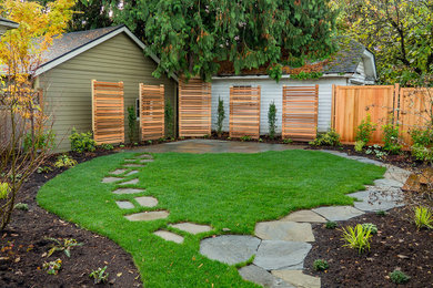 Design ideas for a mid-sized full sun backyard stone landscaping in Portland.