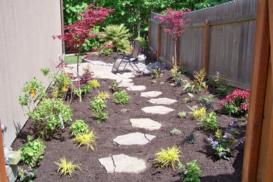 This is an example of a mid-sized traditional full sun side yard stone garden path in Seattle.
