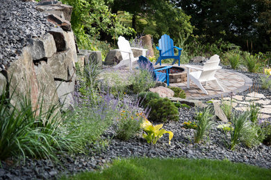 Ejemplo de jardín tradicional grande en patio trasero con muro de contención, exposición parcial al sol y adoquines de ladrillo