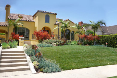 На фото: большой солнечный засухоустойчивый сад на переднем дворе в стиле фьюжн с хорошей освещенностью и мощением тротуарной плиткой с