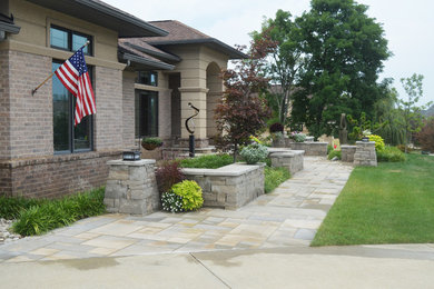 Ejemplo de jardín de estilo americano en patio delantero con adoquines de piedra natural