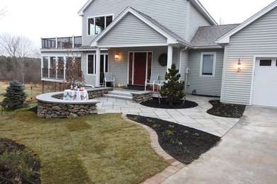Photo of a mid-sized tropical partial sun front yard stone landscaping in Boston for fall.