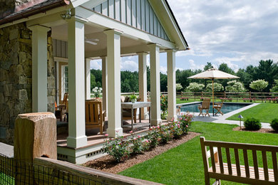 Imagen de jardín clásico grande en verano en patio trasero con exposición parcial al sol y adoquines de hormigón