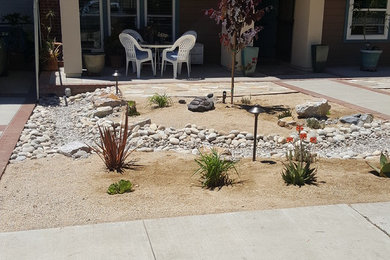 Photo of a mid-sized mediterranean drought-tolerant and partial sun front yard concrete paver garden path in San Diego for summer.
