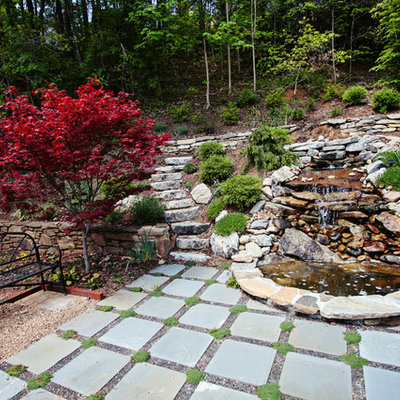 Photo of a mid-sized traditional full sun backyard stone landscaping in Charlotte for summer.