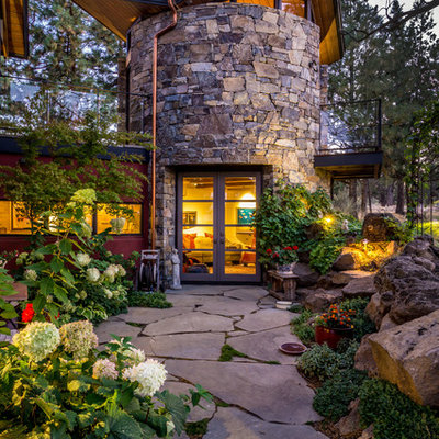 Design ideas for a large rustic full sun backyard stone landscaping in Other.