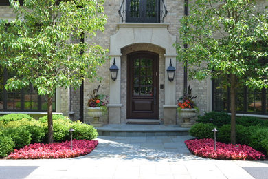 Classic front partial sun garden in Chicago with concrete paving.