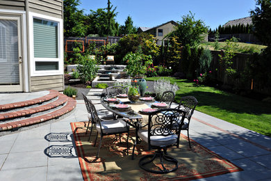 Example of a large trendy backyard stone patio fountain design in Portland