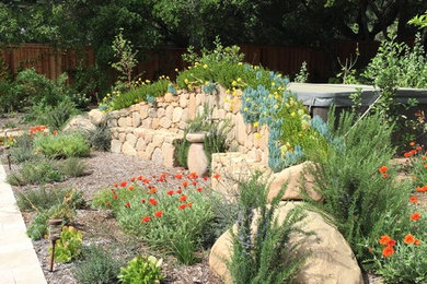 Photo of a mediterranean backyard stone retaining wall landscape in Los Angeles.