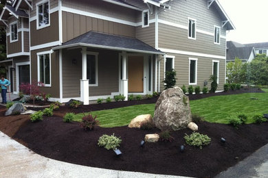 Medium sized classic front driveway partial sun garden for spring in Seattle with a garden path and mulch.