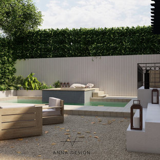 Geometrische, Große Mediterrane Gartenkamin im Sommer, hinter dem Haus mit direkter Sonneneinstrahlung, Granitsplitt und Steinzaun in Los Angeles