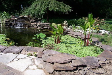 Modelo de jardín en patio con fuente, exposición total al sol y adoquines de piedra natural