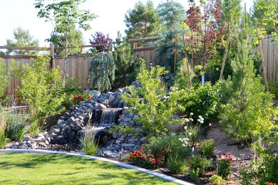 Inspiration for a mid-sized traditional full sun backyard stone water fountain landscape in Other for spring.