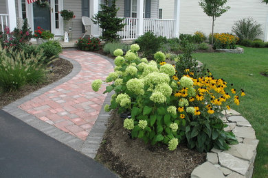 Inspiration for a mid-sized traditional front yard brick landscaping in New York.