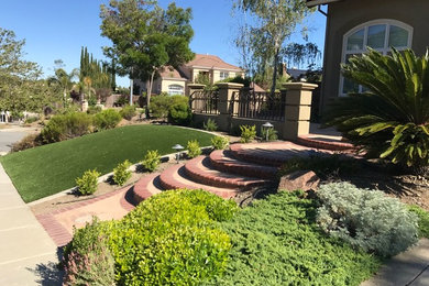 Inspiration for a large classic front driveway full sun garden in San Francisco with brick paving.