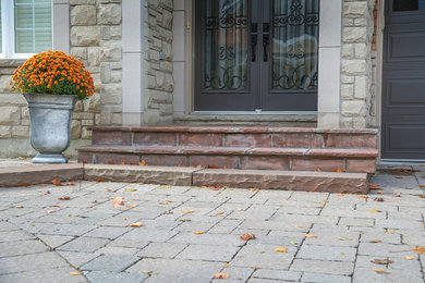 This is an example of a mid-sized traditional full sun front yard concrete paver landscaping in Toronto.